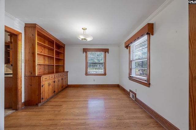 interior space with light hardwood / wood-style floors and crown molding