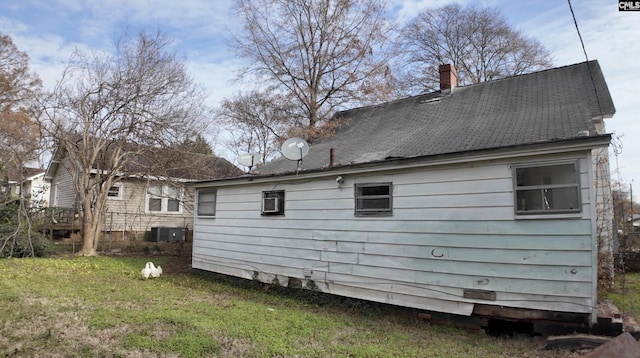 rear view of property with a yard and central AC