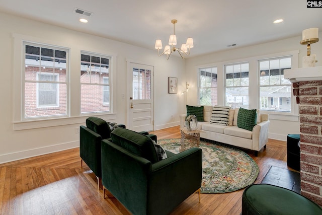 living room with hardwood / wood-style floors and an inviting chandelier