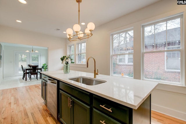 kitchen featuring dishwasher, sink, an island with sink, and hanging light fixtures