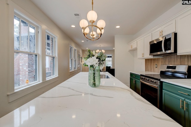 kitchen with light stone countertops, hanging light fixtures, a chandelier, appliances with stainless steel finishes, and green cabinetry