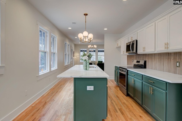 kitchen featuring white cabinetry, a center island, hanging light fixtures, a chandelier, and appliances with stainless steel finishes