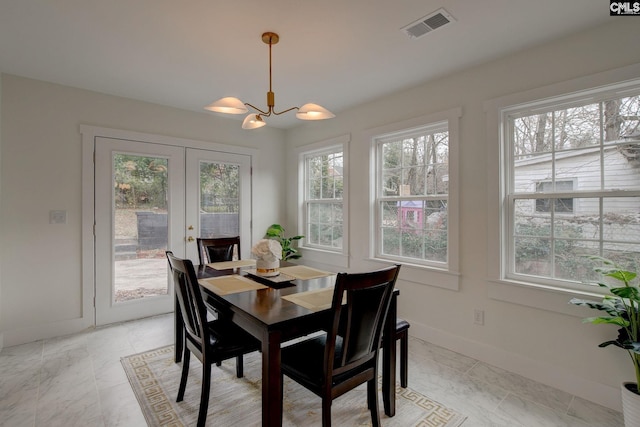 dining room with french doors and a notable chandelier