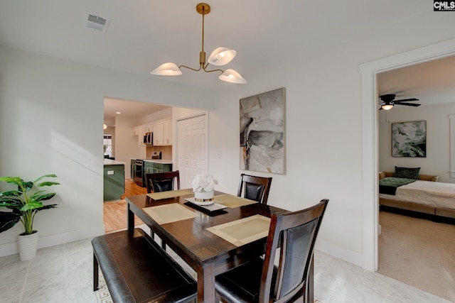 dining room featuring ceiling fan with notable chandelier