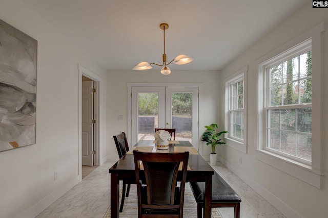 dining area featuring french doors and an inviting chandelier