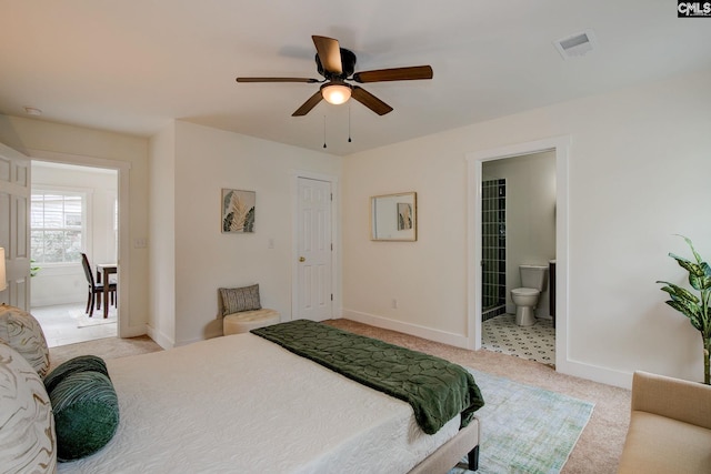 bedroom with ensuite bath, ceiling fan, and light colored carpet