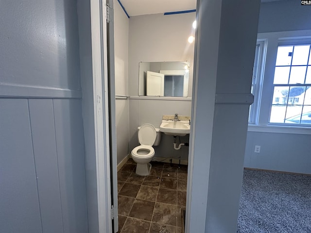 bathroom featuring a healthy amount of sunlight, toilet, and sink