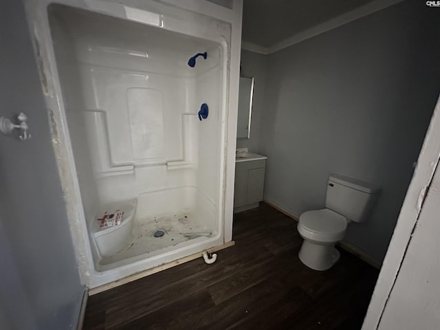 bathroom with a shower, vanity, hardwood / wood-style flooring, and toilet