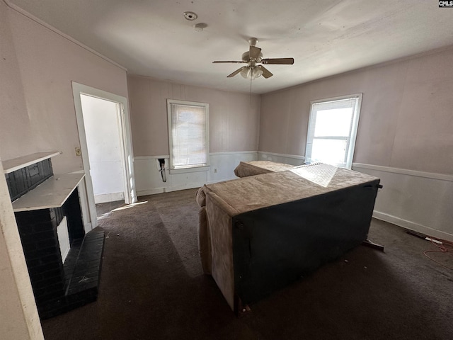 bedroom featuring dark colored carpet, ceiling fan, and multiple windows