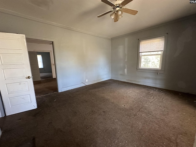 carpeted spare room with ceiling fan and crown molding