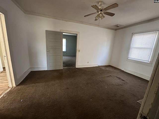 empty room with ceiling fan and dark carpet