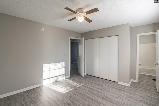 unfurnished bedroom featuring a textured ceiling, a closet, ceiling fan, and light hardwood / wood-style floors