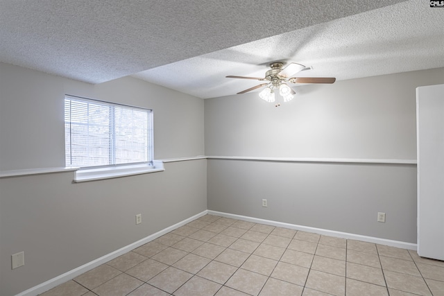 tiled empty room featuring ceiling fan and a textured ceiling