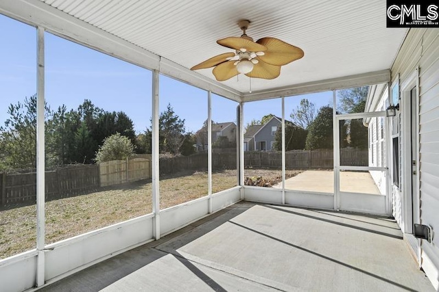 unfurnished sunroom with ceiling fan