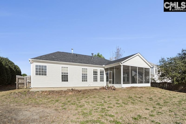 rear view of property featuring a lawn and a sunroom