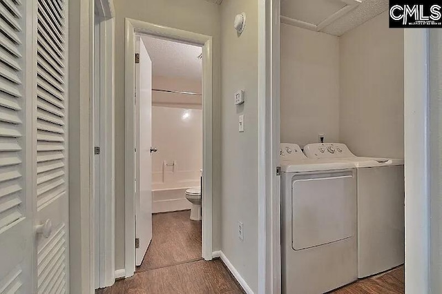 laundry area featuring washer and clothes dryer, hardwood / wood-style floors, and a textured ceiling