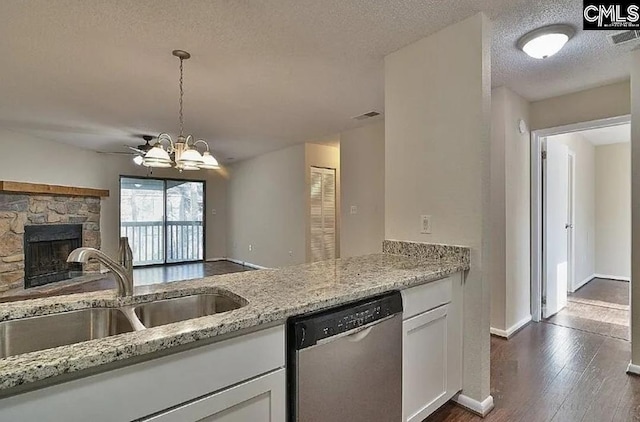 kitchen with sink, light stone counters, stainless steel dishwasher, a textured ceiling, and white cabinets