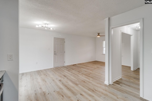 empty room featuring a textured ceiling, light hardwood / wood-style floors, and ceiling fan