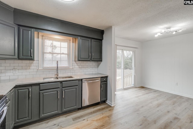 kitchen featuring sink, light stone counters, stainless steel dishwasher, a textured ceiling, and light wood-type flooring