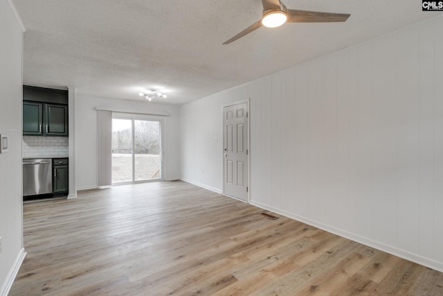 unfurnished living room with ceiling fan, light hardwood / wood-style floors, and a textured ceiling