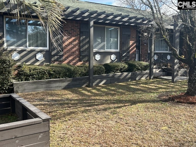 view of side of home with a pergola and a lawn