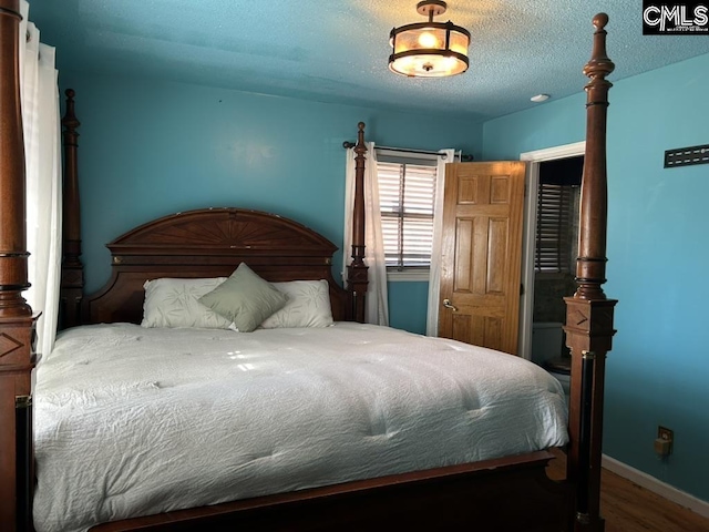 bedroom featuring wood-type flooring and a textured ceiling