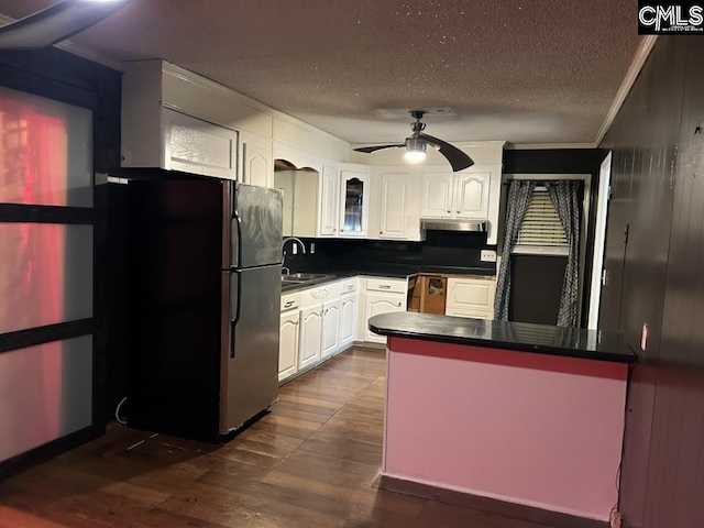 kitchen featuring dark hardwood / wood-style floors, sink, white cabinets, stainless steel fridge, and ceiling fan