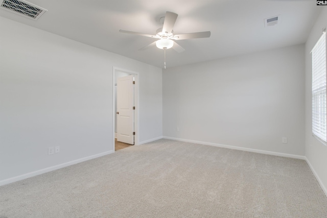 spare room featuring plenty of natural light, ceiling fan, and light carpet