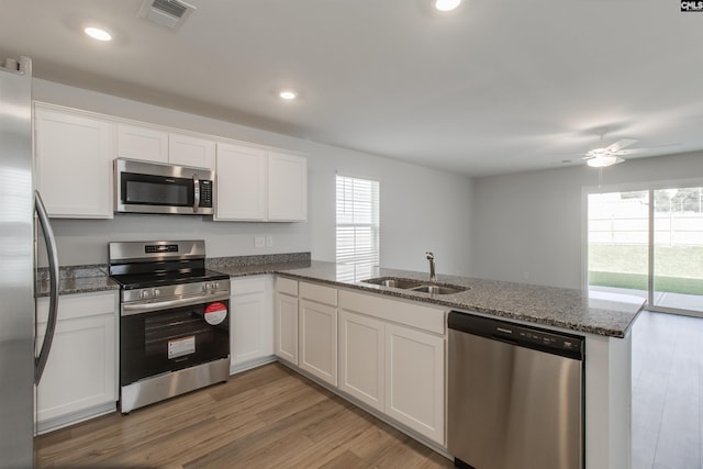 kitchen featuring white cabinets, stainless steel appliances, and kitchen peninsula