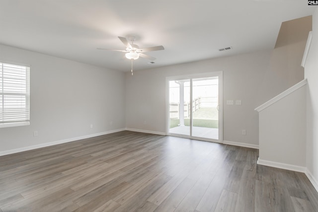 unfurnished room with ceiling fan, hardwood / wood-style floors, and a healthy amount of sunlight