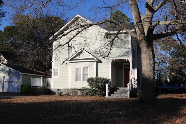 view of front of house with a garage and an outbuilding