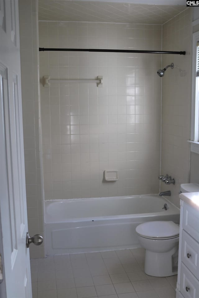 full bathroom with toilet, tile patterned flooring, tiled shower / bath, and vanity