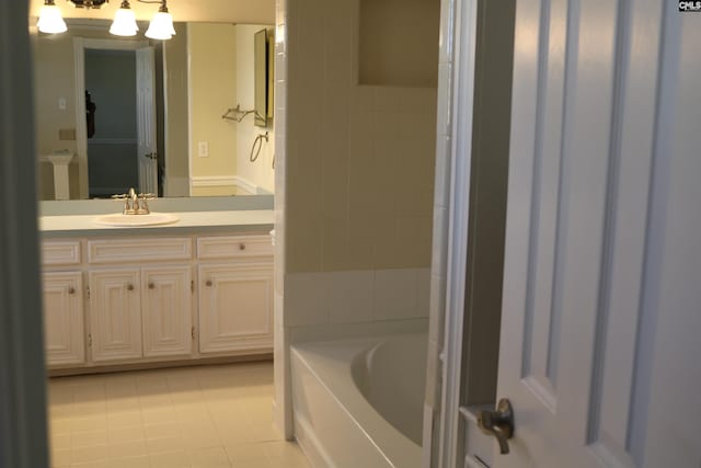 bathroom with vanity, tile patterned flooring, a chandelier, and a bathing tub