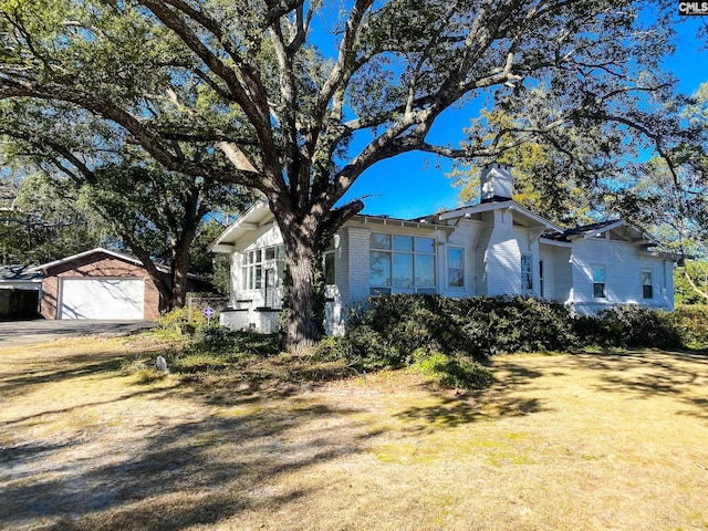 view of front of home with an outbuilding, a garage, and a front yard