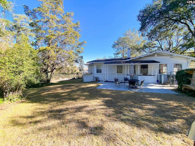 back of property featuring a lawn and a patio