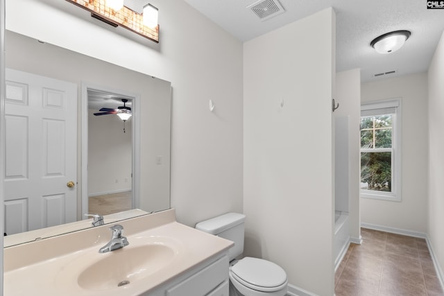 bathroom with ceiling fan, vanity, a textured ceiling, and toilet