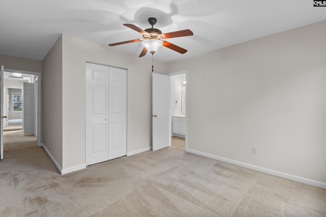 unfurnished bedroom with ceiling fan, light colored carpet, and a closet