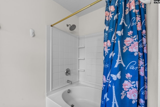 bathroom with shower / bath combo with shower curtain and a textured ceiling