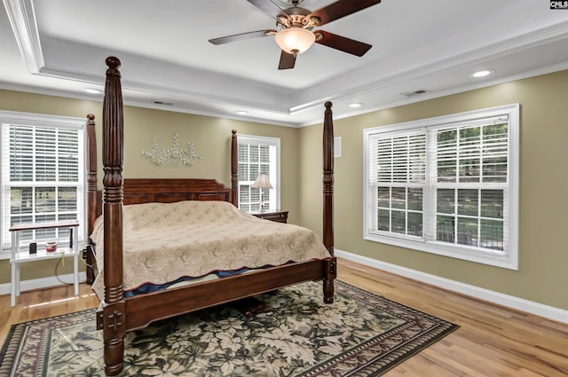 bedroom featuring a tray ceiling, ceiling fan, hardwood / wood-style floors, and crown molding