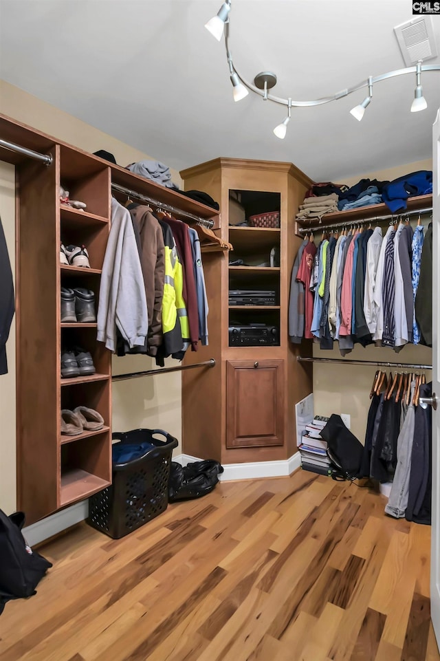 spacious closet with hardwood / wood-style flooring