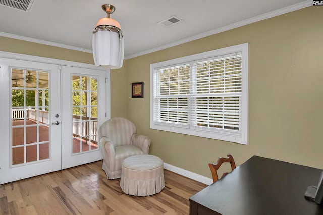 living area with light hardwood / wood-style floors, crown molding, and french doors