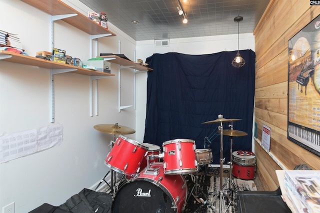 miscellaneous room with wood walls and track lighting