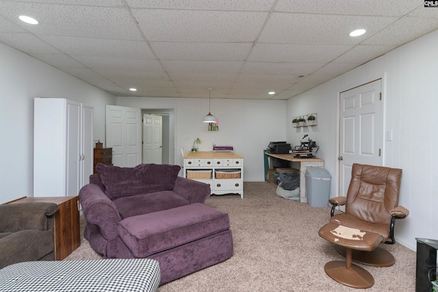 carpeted living room featuring a drop ceiling