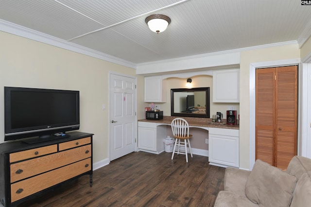 office with dark hardwood / wood-style flooring, built in desk, and ornamental molding