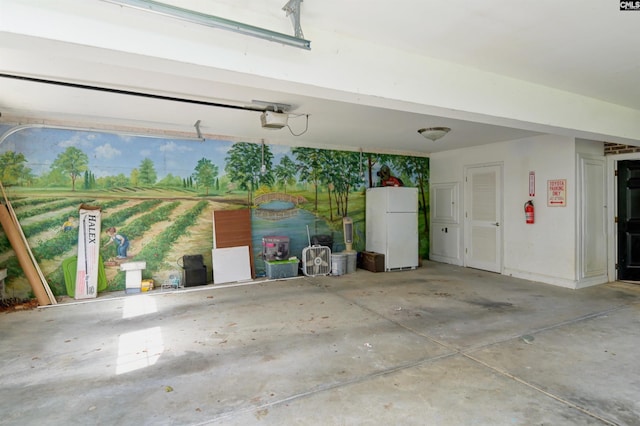 garage featuring white refrigerator and a garage door opener