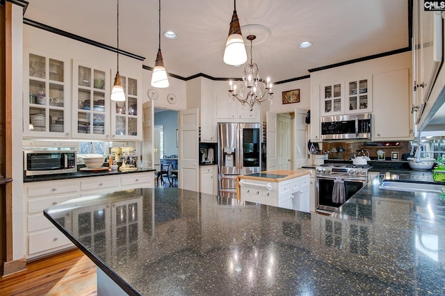 kitchen with white cabinets, stainless steel appliances, and hanging light fixtures