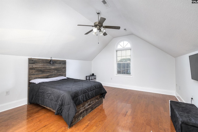 bedroom featuring hardwood / wood-style flooring, ceiling fan, a textured ceiling, and vaulted ceiling