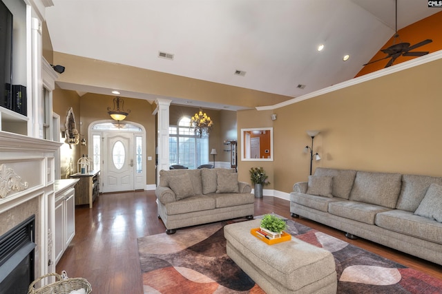 living room with ornate columns, ceiling fan, dark wood-type flooring, a premium fireplace, and vaulted ceiling