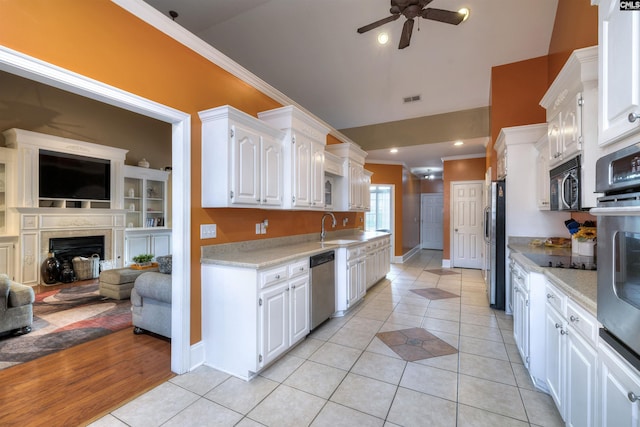 kitchen featuring appliances with stainless steel finishes, white cabinetry, ceiling fan, and light tile patterned flooring