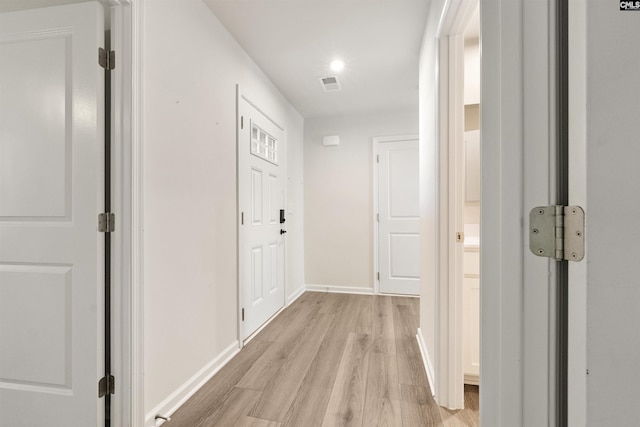 corridor with light hardwood / wood-style floors